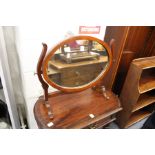 A mahogany oval dressing table mirror.