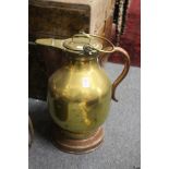 A copper and brass lidded jug.