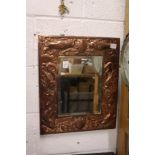 An Arts & Crafts copper framed mirror embossed with fish.