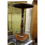 A mahogany circular occasional table on column supports with circular base.