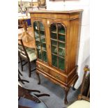 A good small walnut two door display cabinet on stand with two small drawers and carved cabriole