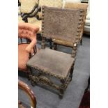 An 18th century oak framed armchair with embossed leather and brass back and seat.