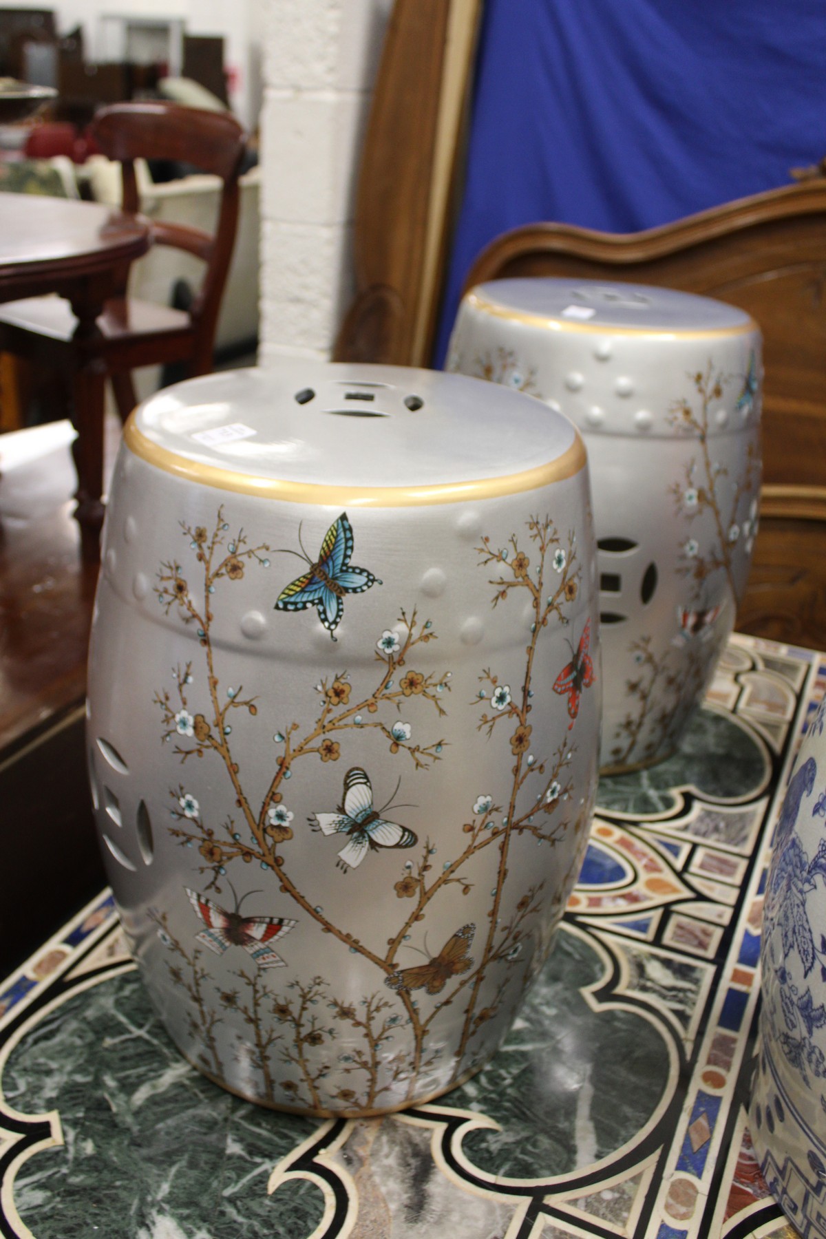 A pair of Chinese barrel seats, silver ground, decorated with butterflies.