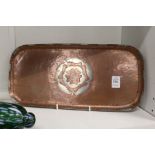 An unusual copper rounded rectangular tray with inlaid decoration, monogrammed.
