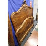 A late 19th century French walnut bedframe with carved decoration.