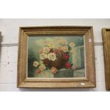 A still life of roses in a basket, oil on canvas, signed, in a decorative gilt frame.