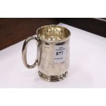 A silver christening mug.