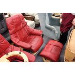 A good Stressless red leather upholstered swivel armchair with matching foot stool.