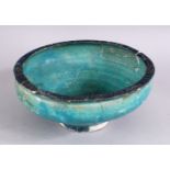 AN EARLY PERSIAN OTTOMAN TURQUOISE GLAZED POTTERY BOWL (repairs and restoration), 19cm diameter.