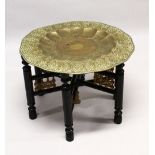A GOOD LARGE ISLAMIC BRASS TRAY TABLE AND FOLDING STAND, with embossed decoration, 76cm diameter.