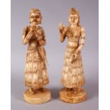 A PAIR OF 19TH CENTURY CARVED INDIAN IVORY FIGURES, one holding a sword, 20cm.