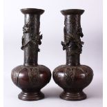 A PAIR OF 18TH CENTURY JAPANESE BRONZE VASES, bulbous shaped and tapering tops with dragons in
