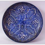 A 19TH CENTURY IZNIK POTTERY DISH, with four quatrefoil panels, 36cm diameter.