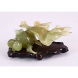 A CHINESE CARVED JADE FIGURE OF A GOLDFISH, on a carved wooden base, 10cm.