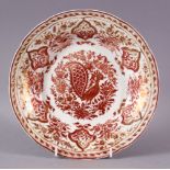 AN ISLAMIC PORCELAIN DISH, with copper lustre decoration, the centre painted with peacock, 25cm