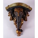 A NICELY CARVED INDIAN ELEPHANT FORMED WALL BRACKET, carved with an elephant head amongst gilded