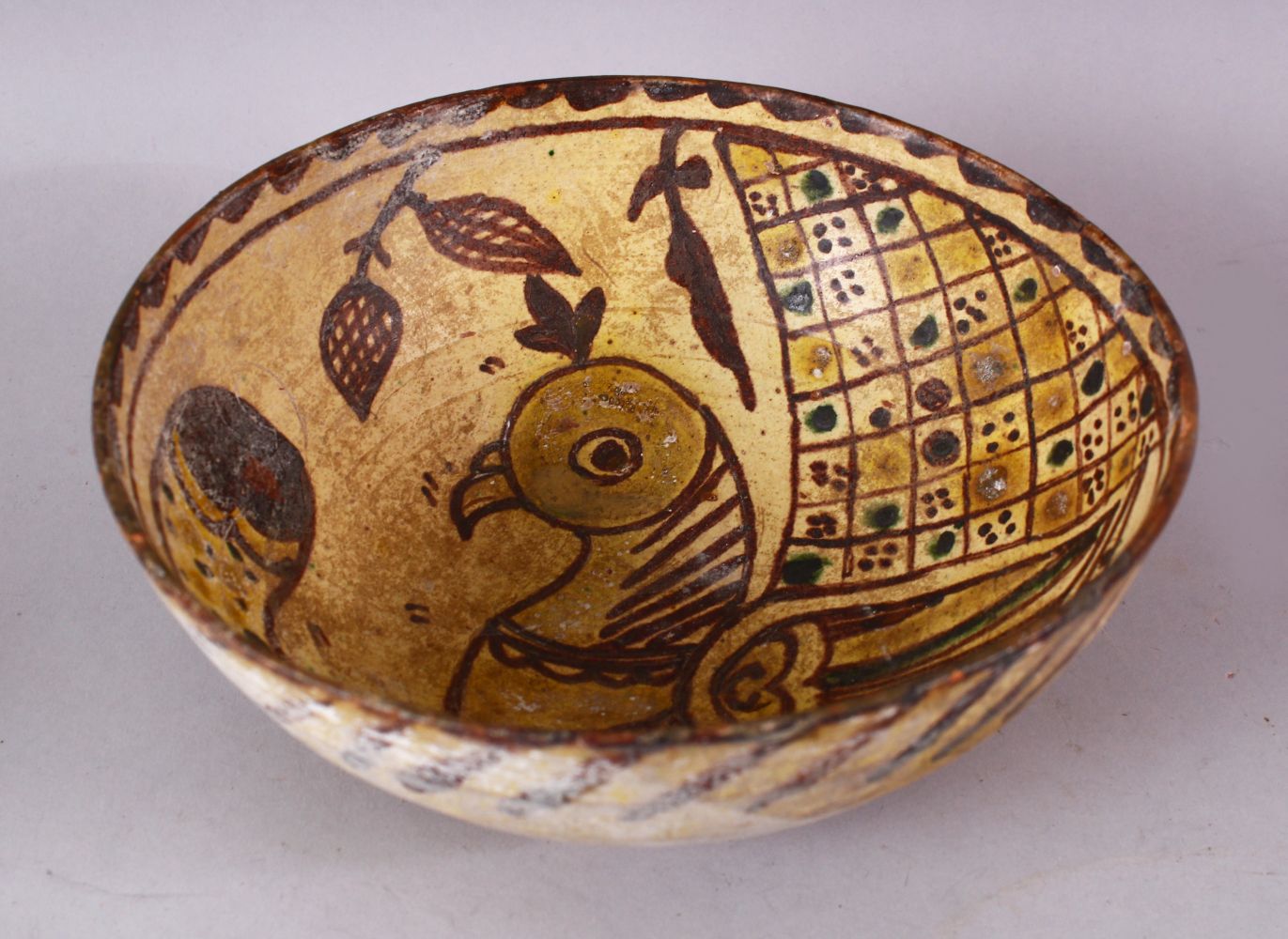 AN EARLY ISLAMIC POTTERY BOWL painted to the interior with a bird, 20cm diameter.