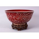 A CHINESE COPPER RED CARVED COPPER RED PORCELAIN DRAGON BOWL, with decoration of dragins amongst