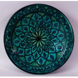 A 20TH CENTURY IZNIK POTTERY CIRCULAR BOWL, green ground painted with flower head design, 39cm