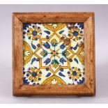 A 19TH / 20TH CENTURY TURKISH POTTERY TILE SECTION, housed within a wooden frame with feet,