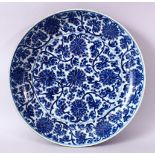 A LARGE CHINESE BLUE, WHITE & COPPER RED PORCELAIN CHARGER, decorated inside with formal floral