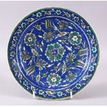 A 19TH/20TH CENTURY PAINTED POTTERY DISH, in the Iznik style, 23cm diameter.