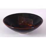 A JIXHOU POTTERY CIRCULAR TEA BOWL, with dark brown glaze, the interior decorated with two leaves,