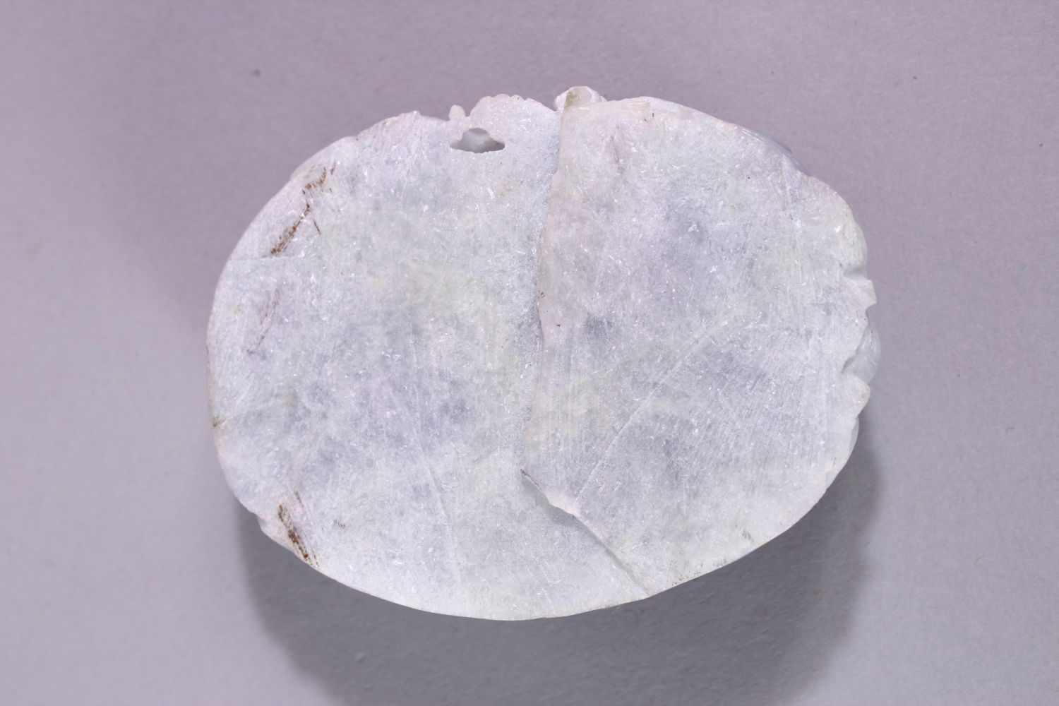 A CHINESE CARVED HARDSTONE ROUNDEL, carved with kylin and naturalistic forms, 8cm x 6cm. - Image 2 of 2