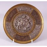 AN INDIAN BRASS CIRCULAR DISH, overlaid with white metal and copper panels, the centre depicting a