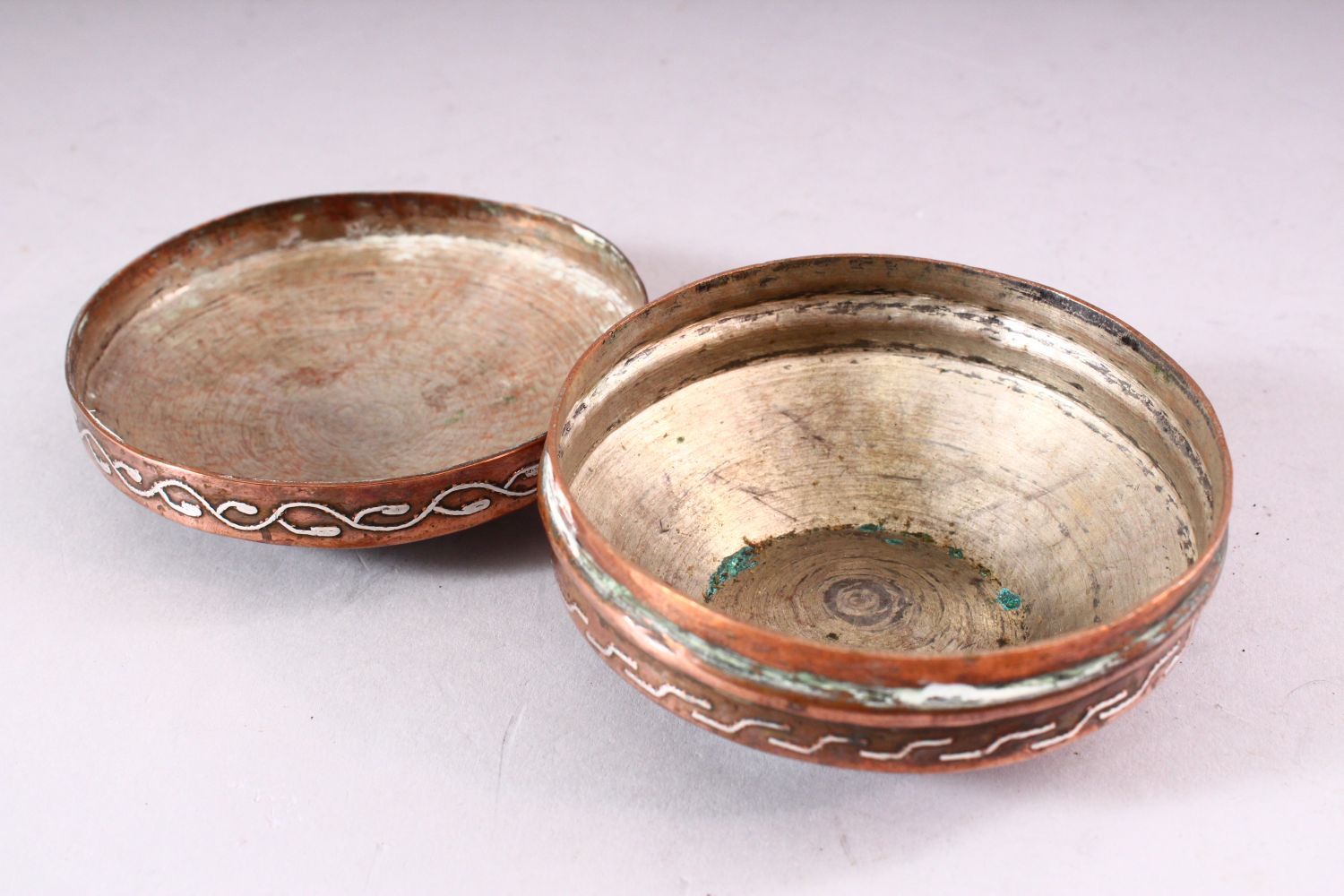 AN ISLAMIC CIRCULAR COPPER BOX AND COVER, the cover with silver inlaid calligraphy, 10cm diameter. - Image 5 of 5