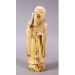 A 17TH / 18TH CENTURY CHINESE CARVED IVORY FIGURE OF A SCHOLAR, stood holding a scroll and his
