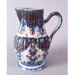 AN 18TH CENTURY CHINESE IMARI RIBBED PORCELAIN JUG, with underglaze blue and orange floral motif