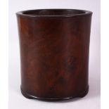 A CHINESE BURR WOOD BRUSH POT, of plain design, on three bracket feet, 16cm high.