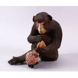 A JAPANESE POTTERY / TERRACOTTA MODEL OF A SEATED MONKEY, the monkey in a seated position holding