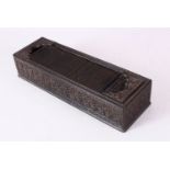A GOOD 19TH CENTURY INDIAN CARVED EBONY RECTANGULAR PEN BOX, with tambour cover, the sides finely