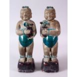 A PAIR OF 19TH CENTURY OR EARLIER CHINESE TURQUOISE AND AUBERGINE GLAZED POTTERY FIGURES OF BOYS,