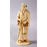 A JAPANESE MEIJI PERIOD CARVED IVORY OKIMONO - MAN, stood in traditional dress, holding his staff