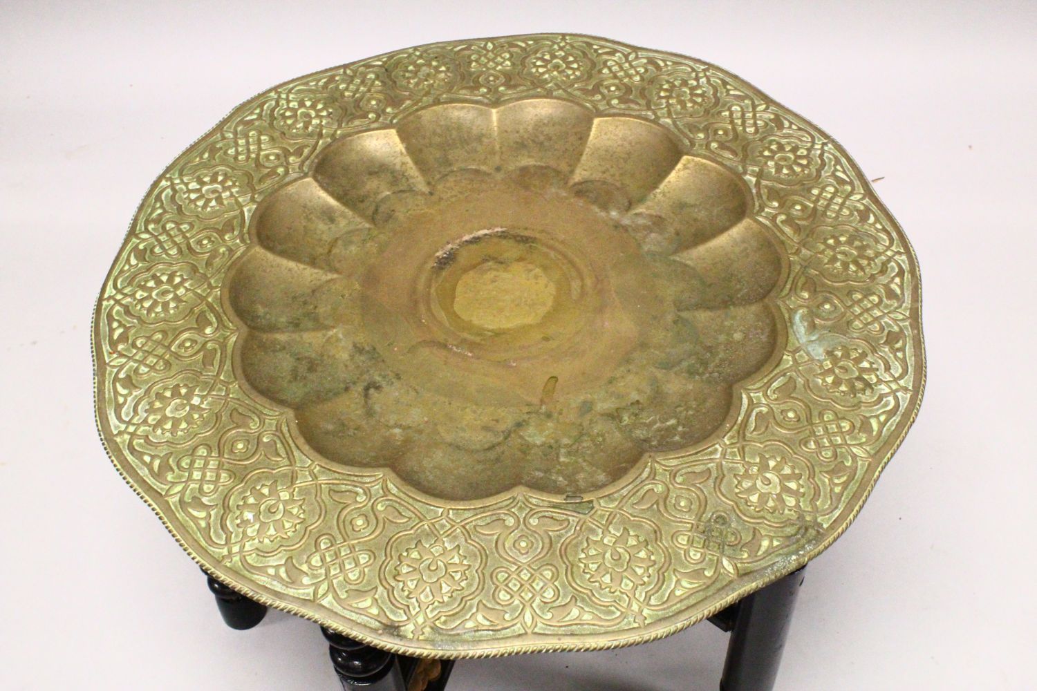 A GOOD LARGE ISLAMIC BRASS TRAY TABLE AND FOLDING STAND, with embossed decoration, 76cm diameter. - Image 2 of 3