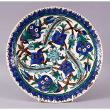 A 19TH CENTURY IZNIK POTTERY CIRCULAR DISH, with a lappet painted border, the centre with green,