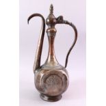 A PERSIAN QAJAR TINNED COPPER EWER, with engraved floral decoration, 43cm high.