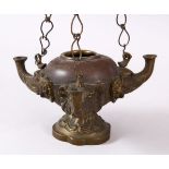 AN INDIAN ELEPHANT FORMED BRONZE HANGING OIL LAMP, with three elephant heads and chains, 16cm wide.