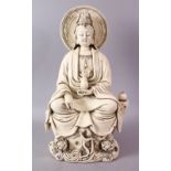 A LARGE CHINESE DEHUA / BLANC DE CHINE PORCELAIN FIGURE OF GUANYIN, in a seated pose upon a rocky