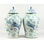 A PAIR OF 20TH CENTURY CHINESE BLUE AND WHITE BALUSTER SHAPE TEMPLE JARS AND COVERS, painted with