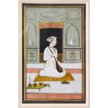 AN INDIAN MINIATURE PAINTING depicting a seated prince holding a sitar, image size 18cm x 11cm.