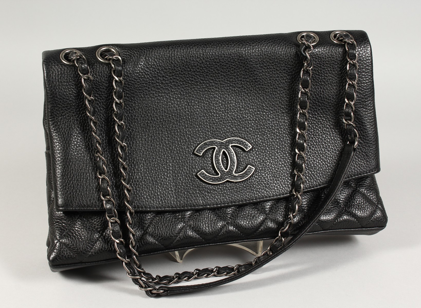 A CHANEL FOLD-UP QUILTED HANDBAG in a Chanel bag.