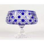 A CUT BLUE CRYSTAL BOHEMIAN CIRCULAR BOWL on square stand. 8ins diameter.