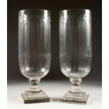 A PAIR OF CUT GLASS STORM LAMPS on square bases. 16ins high.