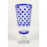 A CUT BLUE CRYSTAL BOHEMIAN TAPERING VASE on square stand. 13ins high.