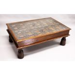 AN EARLY 17TH - 18TH CENTURY DOOR PANEL with iron mounts and rings converted into a coffee table.