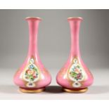 A GOOD SMALL PAIR OF 19TH CENTURY BOHEMIAN PINK GLASS VASES, each painted with three panels of